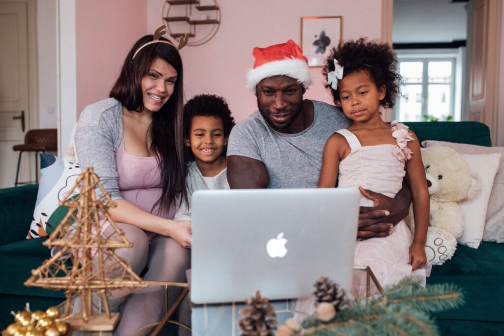 Happy family enjoying a virtual Christmas gathering with decorations indoors.