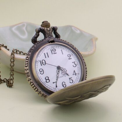 Gold ship pocket watch necklace opened to show the clock face inside.